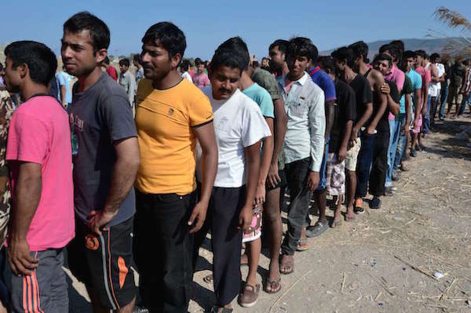 Ilara luzeak Kos hiriko elkartasun talde batek eskaintzen dituen elikagaiak hartzeko (Louisa GOULIAMAKI | AFP) Ilara luzeak Kos hiriko elkartasun talde batek eskaintzen dituen elikagaiak hartzeko (Louisa GOULIAMAKI | AFP)