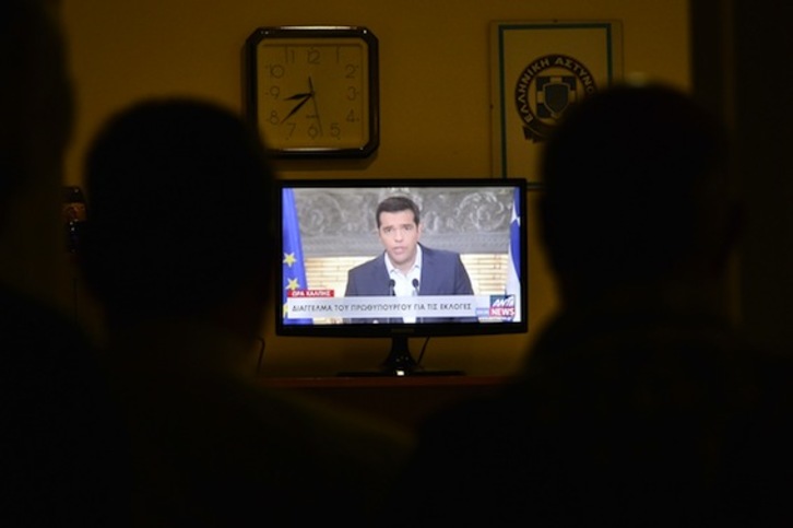 Varios periodistas siguen el discurso de Tsipras por televisión. (Louisa GOULIAMAKI/AFP PHOTO)