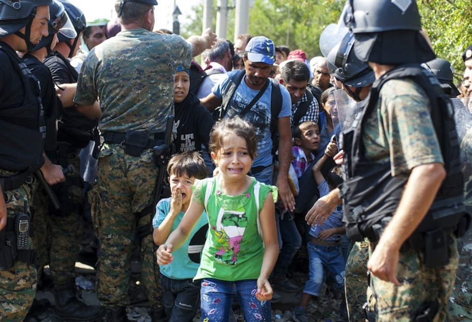 Poliziak etorkinei bidea ireki dien uneko irudia. (Robert ATANASOVSKI/AFP)