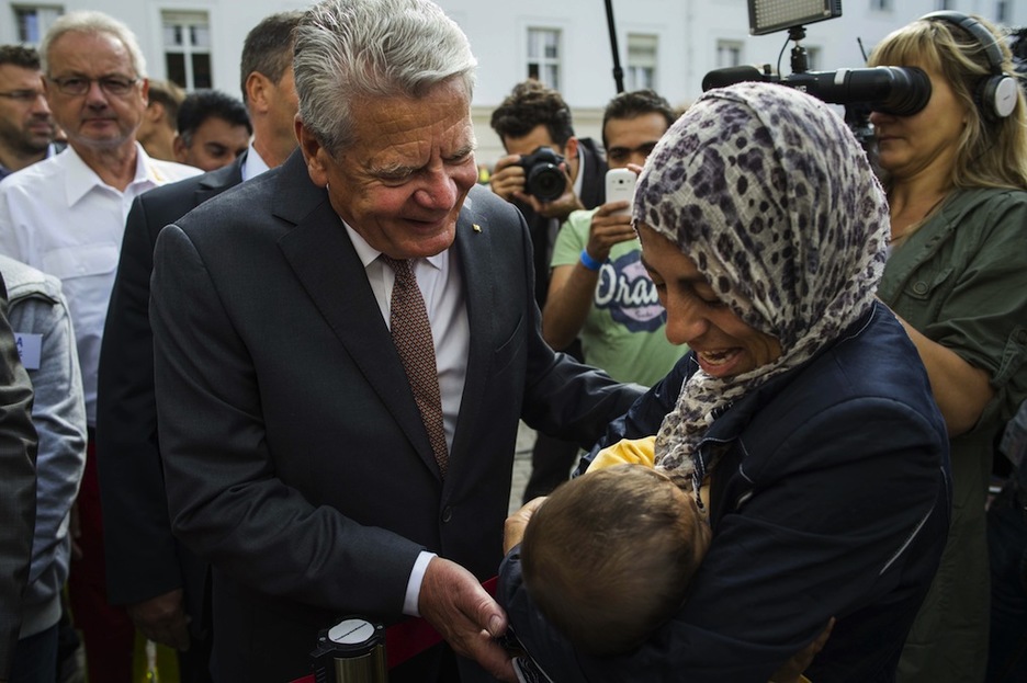 Alemaniako presidente Joachim Gauch Hanna eta bere 7 hilabeteko Adam semearekin hizketan, errefuxiatuen aterpetxean egindako bisita batean. (Odd ANDERSEN/AFP)