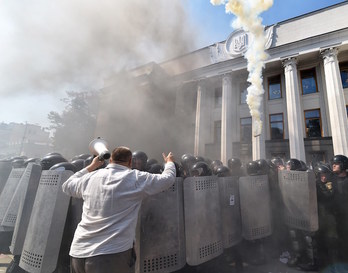 Manifestantes, humo y policías frente al Parlamento en Kiev. (Sergei SUPINSKY | AFP)