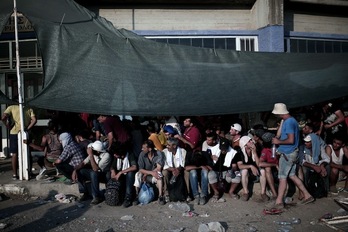 Un grupo de refugiados aguarda en el puerto griego de Lesbos. (Angelos TZORTZINIS/AFP)