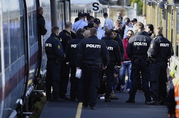 Refugiados y policías daneses, en la estación de Rodby. (Jens Noergaard LARSEN/AFP PHOTO)
