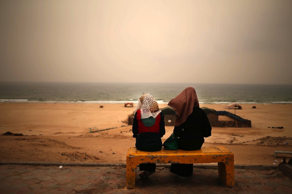 Dos jóvenes observan el mar durante la tormenta de arena. (Mohammed ABED/AFP) 