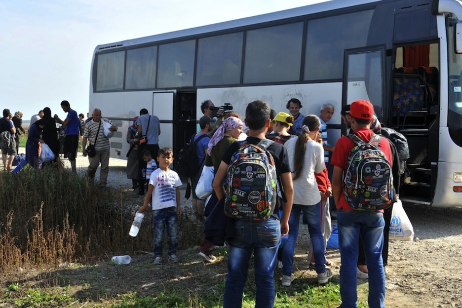 Un grupo de refugiados se suben a un autobús cerca de la frontera entre Serbia y Croacia. (Elvis BARUKCIC / AFP)