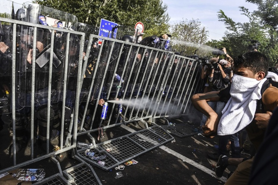 Agentes y refugiados, muy cerca unos de otros. (Armend NIMANI / AFP) Agentes y refugiados, muy cerca unos de otros. (Armend NIMANI / AFP)