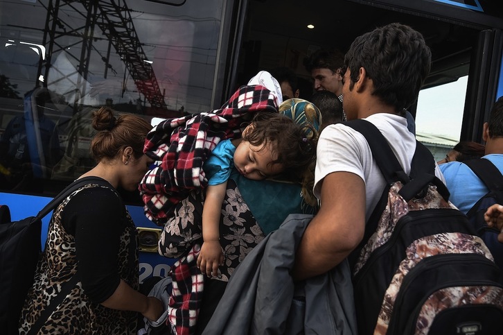 Varios refugiados se suben a un autobús en una estación cercana a Zagreb. (Andrej ISAKOVIC / AFP)