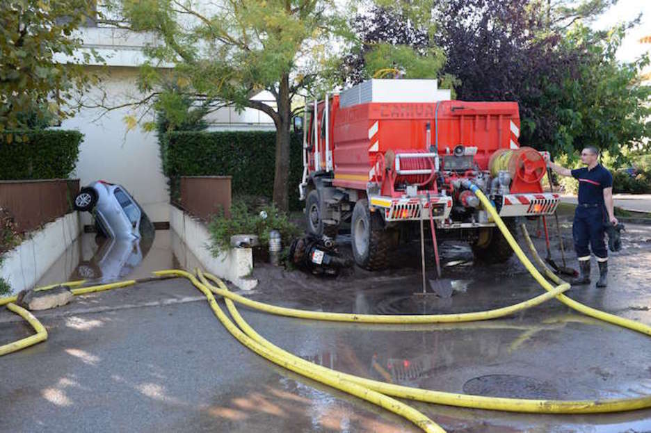 Bomberos tratan de drenar el agua en las casas anegadas (Boris HORVAT | AFP)