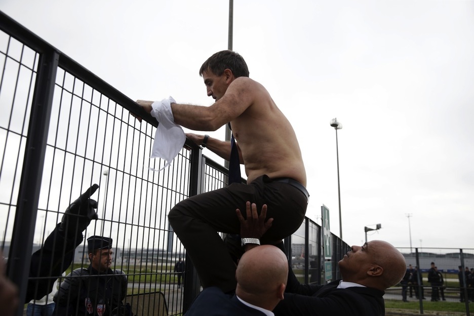 Broseta es ayudado a encaramarse a la valla. (Kenzo TRIBOUILLARD/AFP)