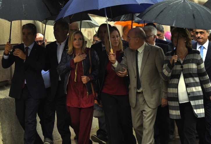 Joana Ortega llega a los juzgados acompañada por miembros del gobierno y de su partido. (Lluis GENE / AFP)