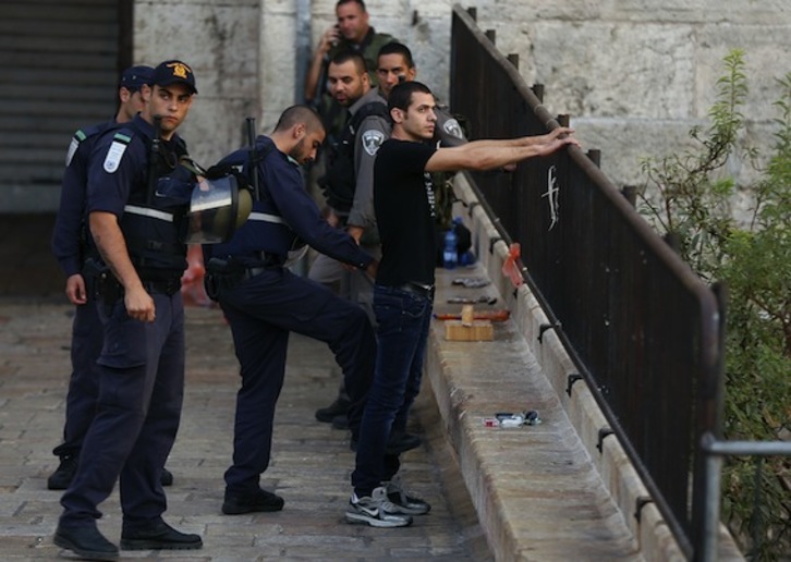 La Policía israelí cachea a un joven palestino junto a la Puerta de Damasco, en Jerusalén. (Ahmad GARABLI/AFP PHOTO)