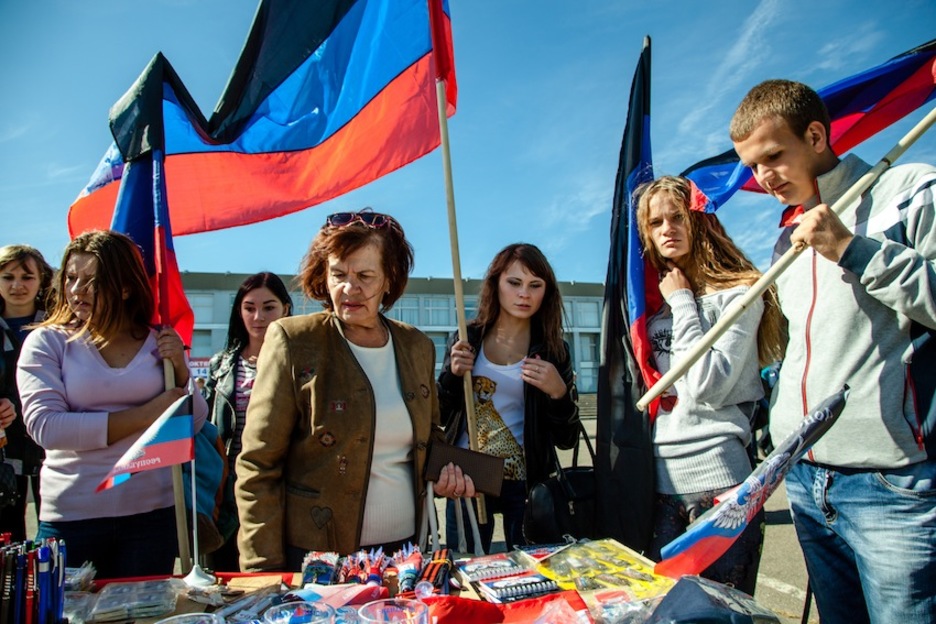 Varias personas observan un puesto de material propagandístico de la República Popular de Donetsk, antes de un acto electoral celebrado en el Estadio Olímpico de Donetsk. (Juan TEIXEIRA)