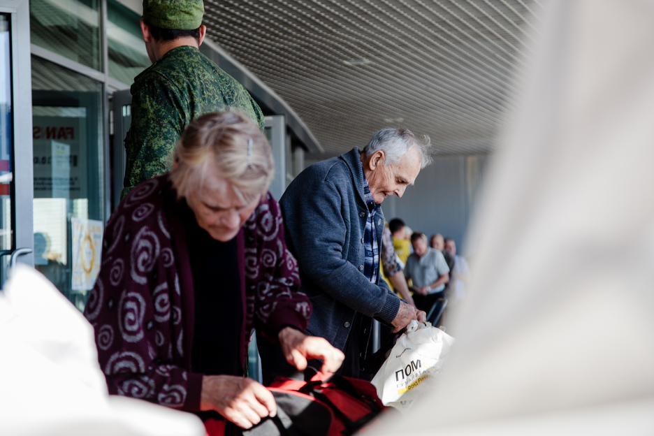 Dos ancianos recogen un paquete de ayuda humanitaria ofrecida por el oligarca Ajmétov en el estadio Donbass Arena, donde antes del conflicto jugaba el Shaktar Donetsk. (Juan TEIXEIRA) 