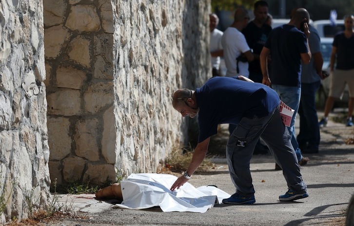 Un sanitario israelí cubre el cuerpo del adolescente palestino tiroteado en Jerusalén. (Ahmad GHARABLI/AFP)