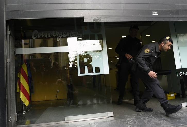 Agentes de la Guardia Civil abandona la sede de CDC. (Lluis GENE / AFP) 