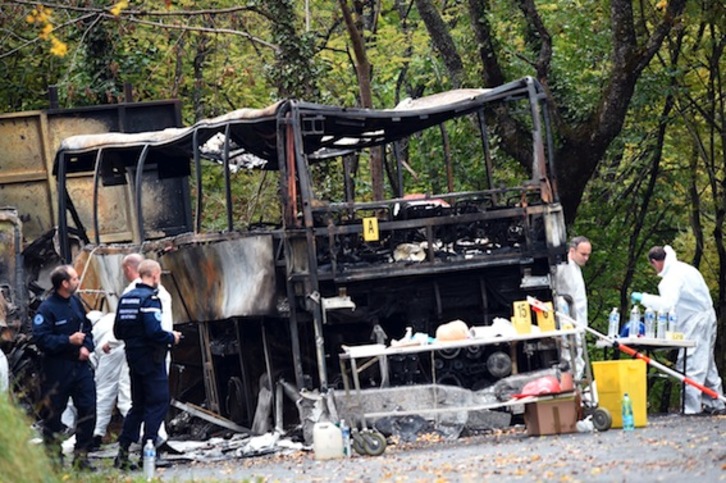Efectivos de la Policía investigan entre los restos del autobús calcinado. (Mehdi FEDOUACH/AFP)
