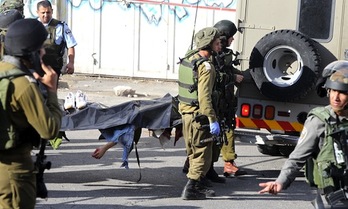 Soldados israelíes transportan el cuerpo del joven palestino. (Hazem BADER/AFP PHOTO)