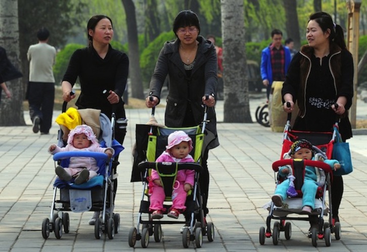 Tres mujeres pasean con sus hijos por un parque de Pekín. (Frederic J. BROWN/AFP PHOTO)