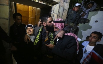 Allan abraza a su madre y su padre tras quedar en libertad. (Jaafar ASHTIYEH / AFP) 