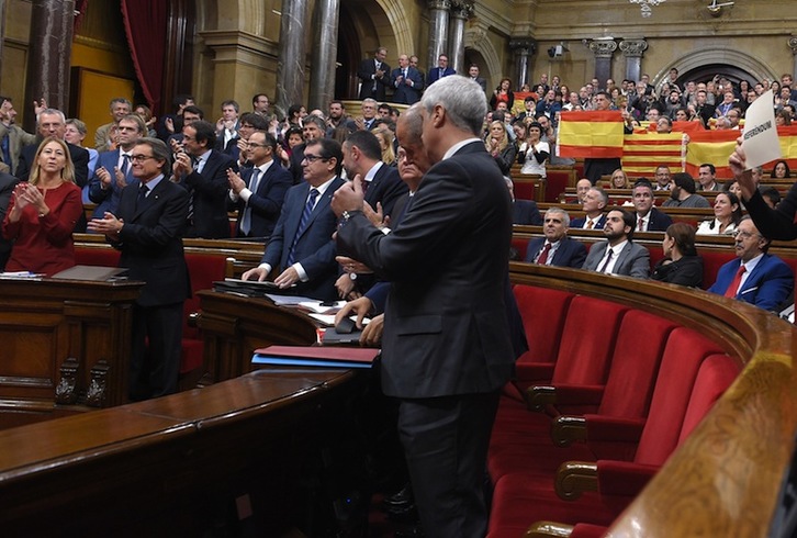 Mientras los parlamentarios independentistas aplauden, los unionistas muestran banderas españolas y Podemos pide un referéndum. (Lluìs GENE/AFP)