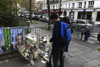 Bi gazte, Bataclan diskotekaren inguruan jarritako lore sortei begira. (Miguel MEDINA/AFP)