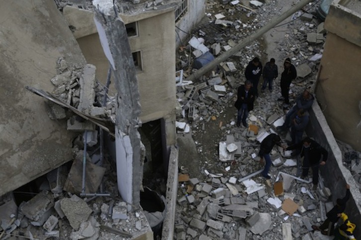 Herritar palestinarrak, Israelek eraitsi duen eraikinaren arrastoei begira. (Abbas MOMANI/AFP PHOTO)