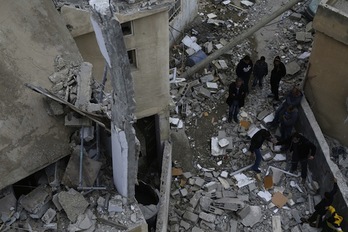 Herritar palestinarrak, Israelek eraitsi duen eraikinaren arrastoei begira. (Abbas MOMANI/AFP PHOTO)