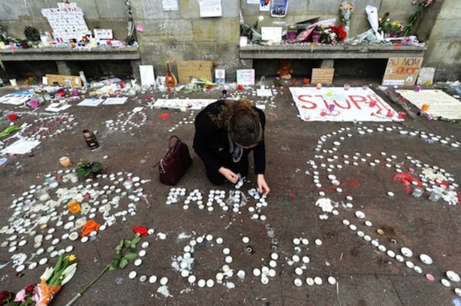 Una mujer coloca velas en recuerdo a los fallecidos, en Toulouse. (Eric CABANIS/AFP PHOTO)