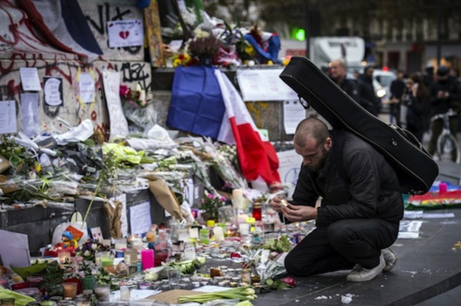 Un hombre prende una vela en la Plaza de la República, en París. (Lionel BONAVENTURE/AFP)