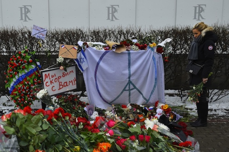 Una mujer, en el memorial erigido en la Embajada francesa de Moscú. (Dmitry SEREBRYAKOV/AFP)