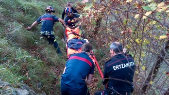 La mujer accidentada en Txindoki es trasladada en camilla por bomberos y ertzainas. (BIDASOAKO SUHILTZAILEAK)
