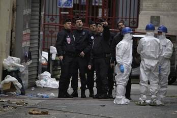 Forenses y agentes de la Policía, en la zona del apartamento asaltado en Saint Denis. (Kenzo TRIBOUILLARD/AFP)