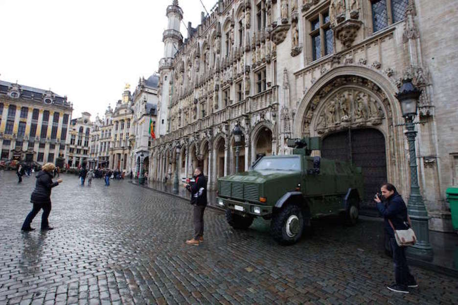 Turistas se hacen fotos frente a un vehículo militar en Grande Place (Nicolas MAETERLINCK | AFP)