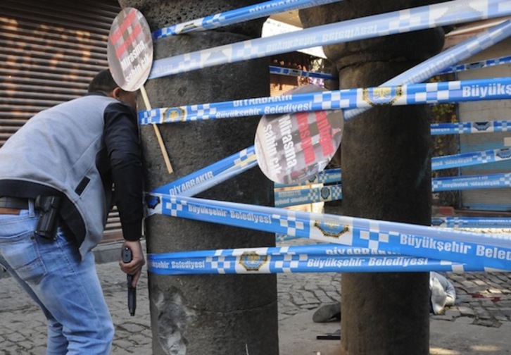 El cuerpo de Elçi yace en el suelo, mientras un oficial de Policía se resguarda tras una columna. (AFP)
