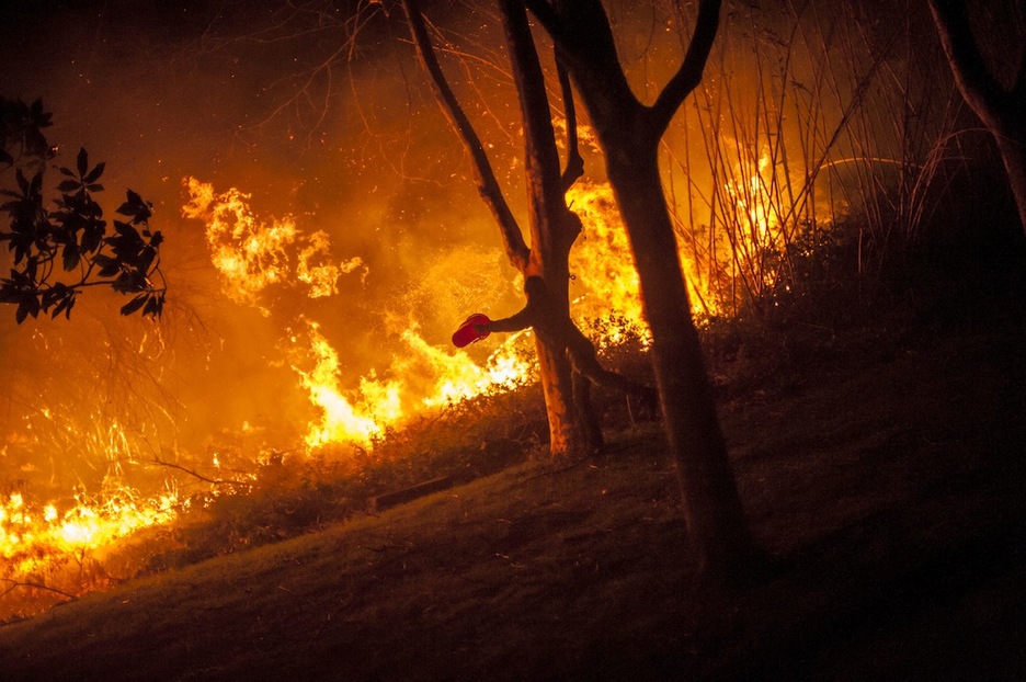 Una persona arroja agua con un balde. (Andoni LUBAKI / ARGAZKI PRESS)