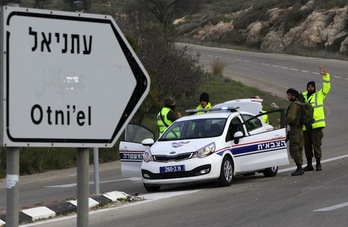 Miembros de las fuerzas de seguridad israelíes, en el acceso al asentamiento de Otniel. (Hazem BADER/AFP)