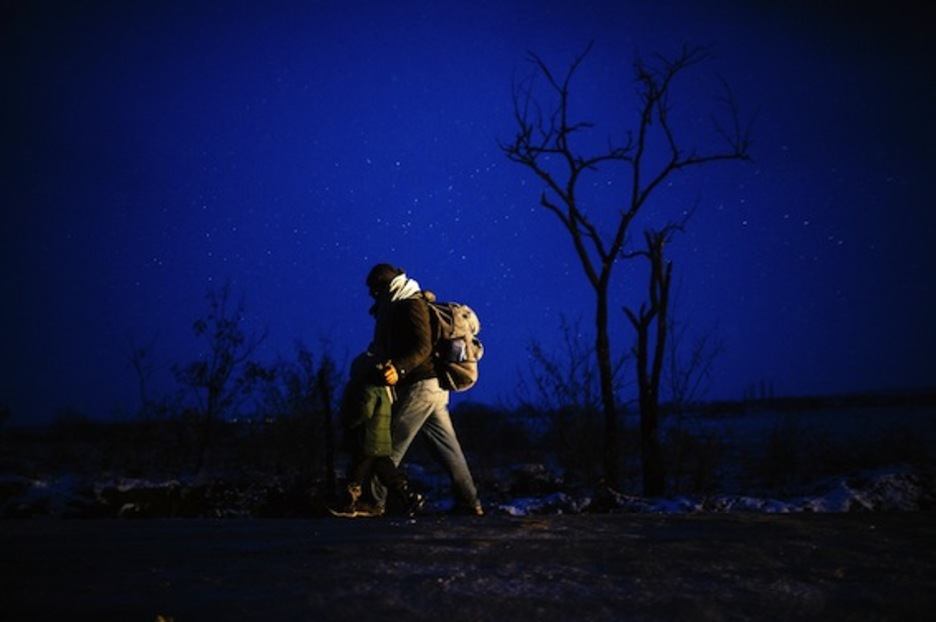 Un hombre camina con su hijo pequeño. (Dimitar DILKOFF/AFP)
