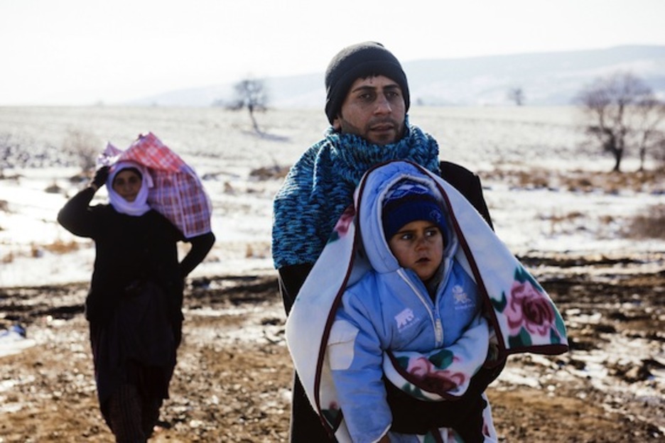Un hombre, con su hijo en brazos. (Dimitar DILKOFF/AFP)