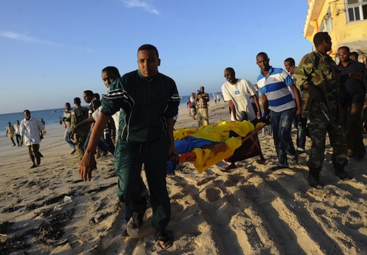 Varios hombres evacúan el cadáver de uno de los fallecidos en el ataque. (Mohamed ABDIWAHAB/AFP)