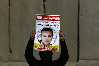 Un palestino sujeta un cartel pidiendo la liberación de Muhammad al-Qiq. (Abbas MOMANI / AFP)