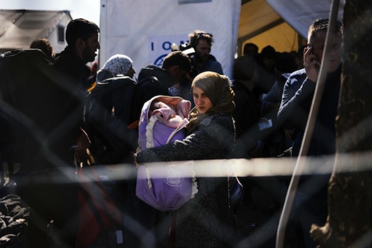 Una refugiada, con un bebé en brazos en la frontera entre Grecia y Macedonia. (Dimitar DILKOFF/AFP)
