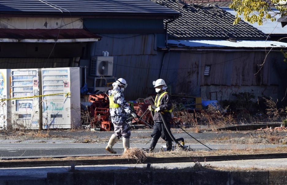 Dos operarios trabajando en las tareas de limpieza. (TORU YAMANAKA / AFP)