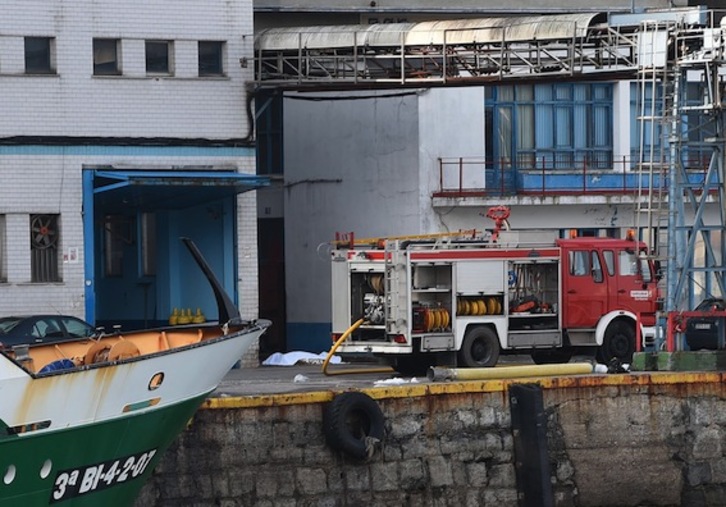 Un camión de bomberos en el exterior de la fábrica de Ondarroa, con el cadáver de uno de los fallecidos al fondo. (ARGAZKI PRESS)