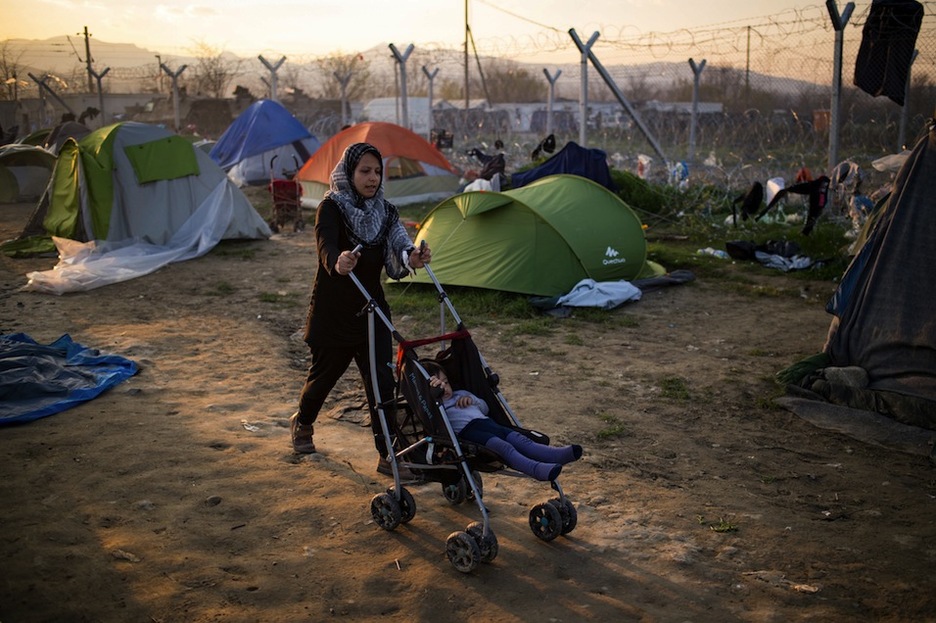 Una mujer, junto a su hija, en el campamento de Idomeni. (Andrej ISAKOVIC / AFP)