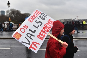 Dos jóvenes sostienen un cartel en el que se lee «Tu reforma la mandamos a ‘valls-ear’», en un juego de palabras con su apellido. (Alain JOCART/AFP)
