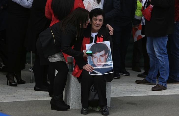 Una mujer, con la imagen de una de las víctimas. (GEOFF CADDICK / AFP)