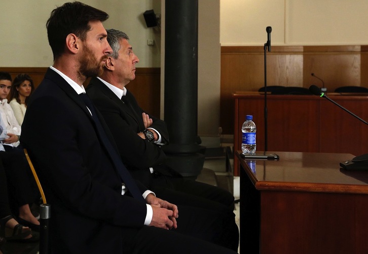 Leo Messi, junto a su padre, durante la sesión del juicio celebrado hoy. (Alberto ESTEVEZ / AFP)
