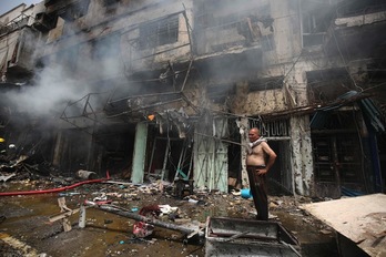 Un hombre en el lugar donde ha estallado uno de los coches bomba. (Ahmad AL-RUBAYE/AFP) 
