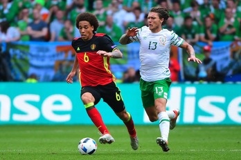 El centrocampista belga Axel Witsel corre ante el centrocampista irlandés Jeffrey Hendrick. (Emmanuel DUNAND/AFP)