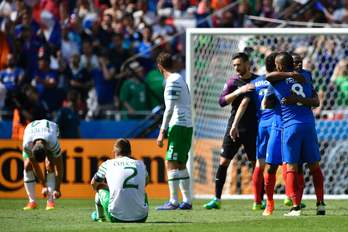 Irlandesas lamentan la eliminación en el suelo mientras el equipo francés disfruta del pase a cuartos. (Martin BUREAU / AFP)